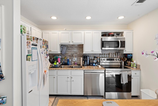 3397 Northside Dr Unit 4, Key West, FL 33040 - kitchen featuring appliances with stainless steel finishes, tasteful backsplash, white cabinets, light tile patterned floors, and recessed lighting