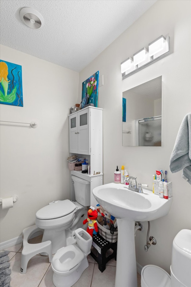 3397 Northside Dr Unit 4, Key West, FL 33040 - bathroom with a shower with door, tile patterned flooring, a textured ceiling, and a bidet