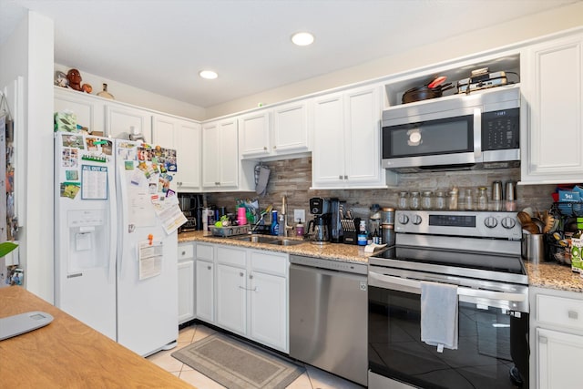 3397 Northside Dr Unit 4, Key West, FL 33040 - kitchen with stainless steel appliances, light tile patterned floors, white cabinets, decorative backsplash, and recessed lighting