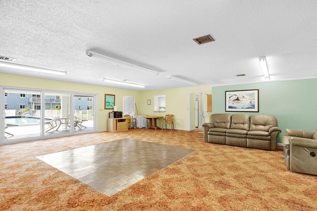 interior space featuring carpet, visible vents, and a textured ceiling
