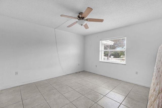 spare room featuring baseboards, a textured ceiling, and a ceiling fan
