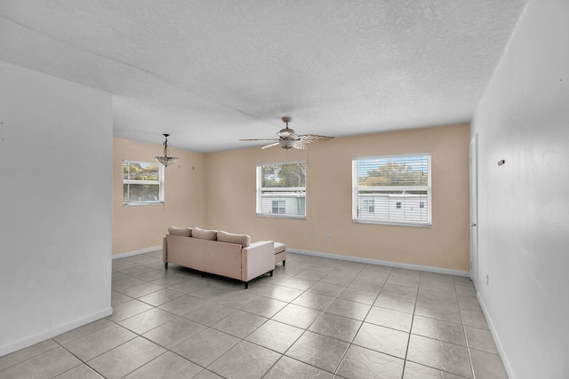 unfurnished living room with light tile patterned flooring, baseboards, a textured ceiling, and ceiling fan