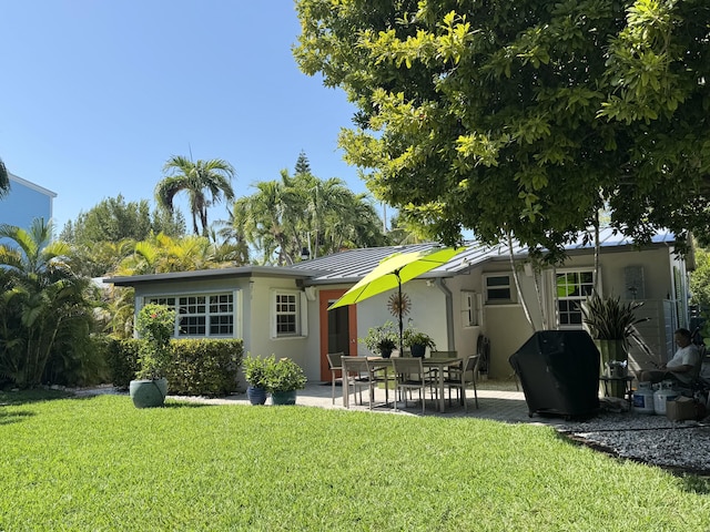 1728 Laird St, Key West, FL 33040 - rear view of house featuring stucco siding, a lawn, and a patio