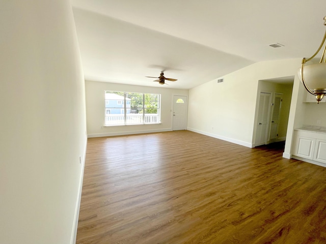 empty room featuring vaulted ceiling, dark hardwood / wood-style floors, and ceiling fan