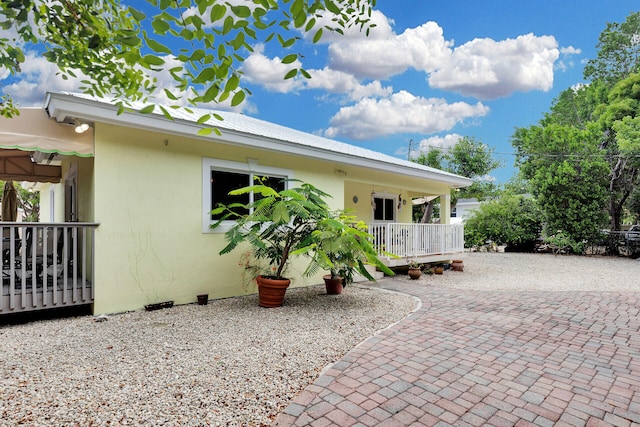 1 Sunset Rd, Key Largo, FL 33037 - view of front of property featuring stucco siding, a patio, and a metal roof