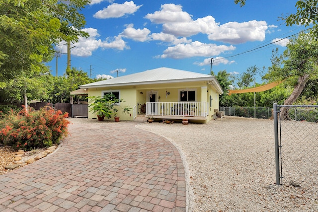 1 Sunset Rd, Key Largo, FL 33037 - view of front facade featuring stucco siding, decorative driveway, a gate, and a metal roof