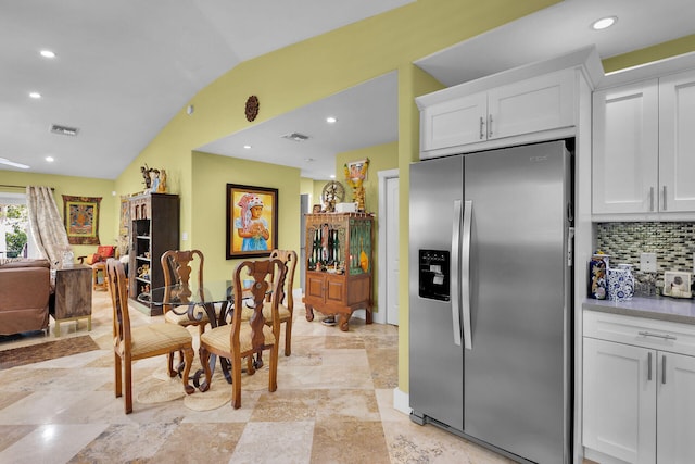 1 Sunset Rd, Key Largo, FL 33037 - kitchen featuring stainless steel refrigerator with ice dispenser, vaulted ceiling, white cabinetry, decorative backsplash, and recessed lighting