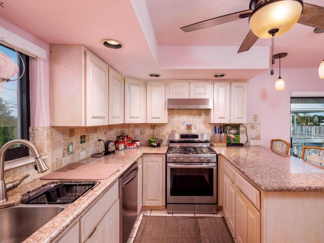 kitchen with sink, gas stove, tasteful backsplash, hanging light fixtures, and black dishwasher