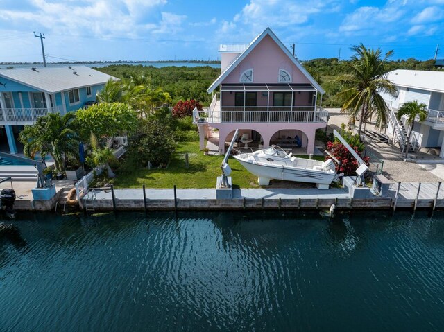 rear view of house with a sunroom and a water view