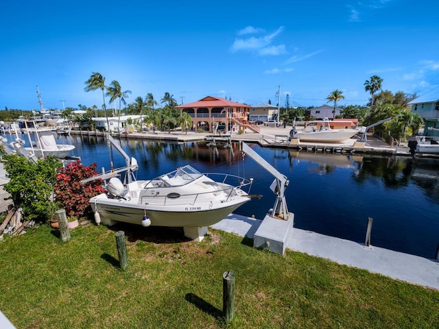 view of dock with a water view and a yard