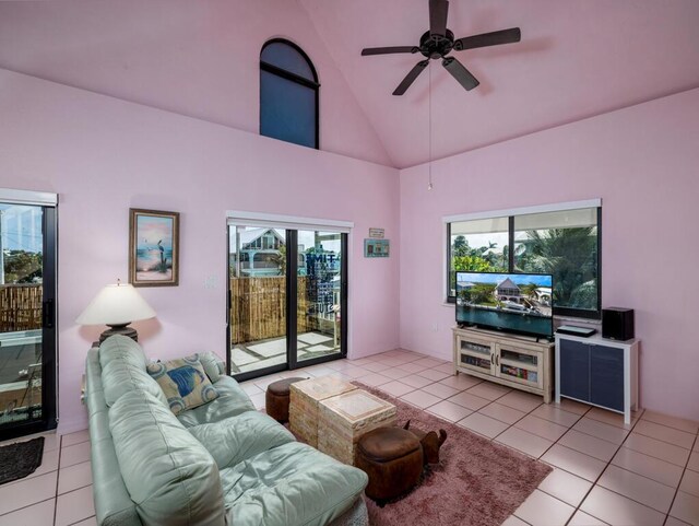 tiled living room with ceiling fan and high vaulted ceiling