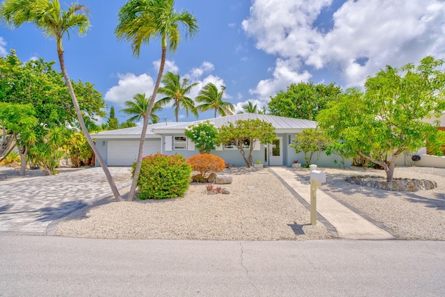 20735 W 5th Ave, Cudjoe, FL 33042 - ranch-style home with driveway, a garage, stucco siding, and a metal roof