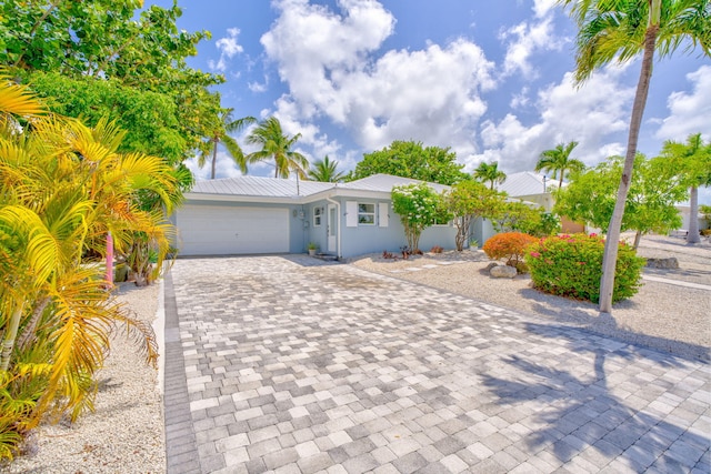 20735 W 5th Ave, Cudjoe, FL 33042 - view of front of house with decorative driveway, a garage, and stucco siding