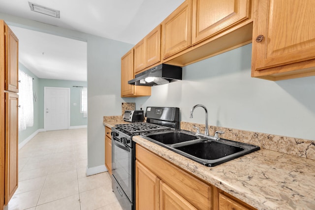 kitchen with light tile patterned flooring, black range with gas cooktop, sink, and light brown cabinets