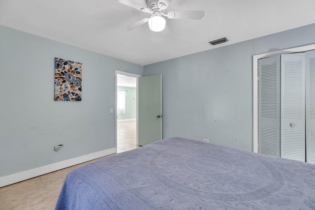 bedroom featuring ceiling fan, a closet, and light tile patterned floors