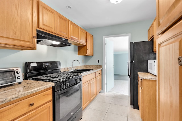 kitchen featuring light brown cabinetry, sink, light stone counters, light tile patterned floors, and black appliances