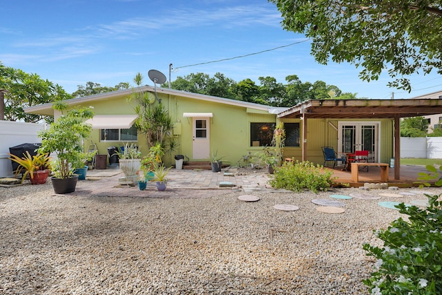 back of house featuring a deck and a patio area