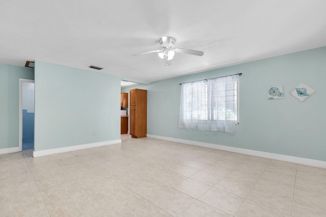 tiled empty room featuring ceiling fan