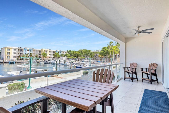 balcony featuring a water view and ceiling fan