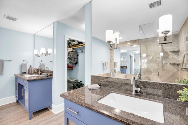 bathroom featuring hardwood / wood-style flooring, vanity, and walk in shower