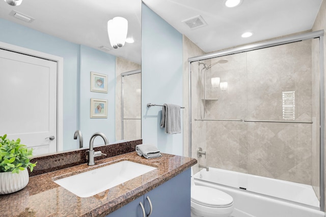 full bathroom with toilet, vanity, and bath / shower combo with glass door