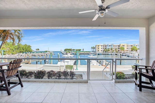 balcony featuring a water view and ceiling fan