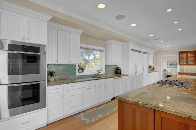 kitchen featuring white cabinetry, stainless steel appliances, and light stone counters