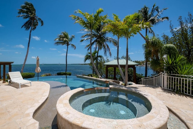 view of pool with an in ground hot tub, a water view, a patio area, and a gazebo