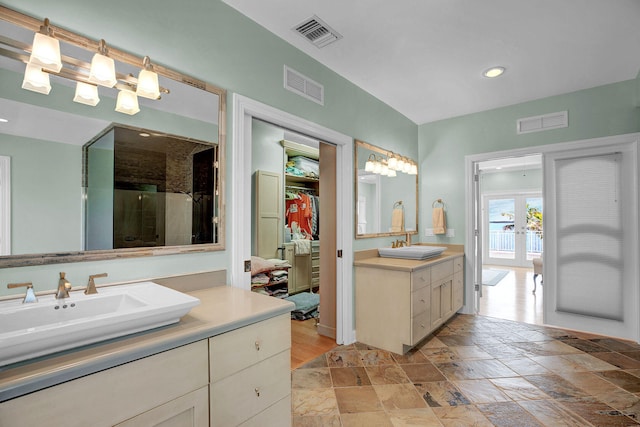 bathroom featuring vanity, a shower with shower door, and french doors