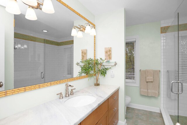 bathroom with a shower with door, vanity, tile patterned flooring, and toilet