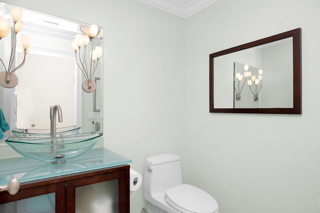 bathroom with crown molding, vanity, and toilet