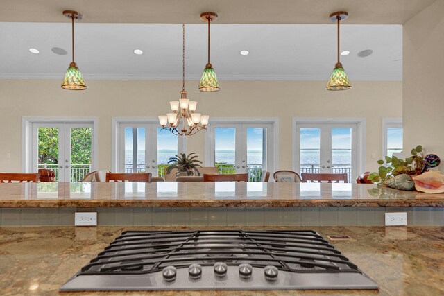 kitchen featuring stainless steel gas cooktop, decorative light fixtures, french doors, and a water view