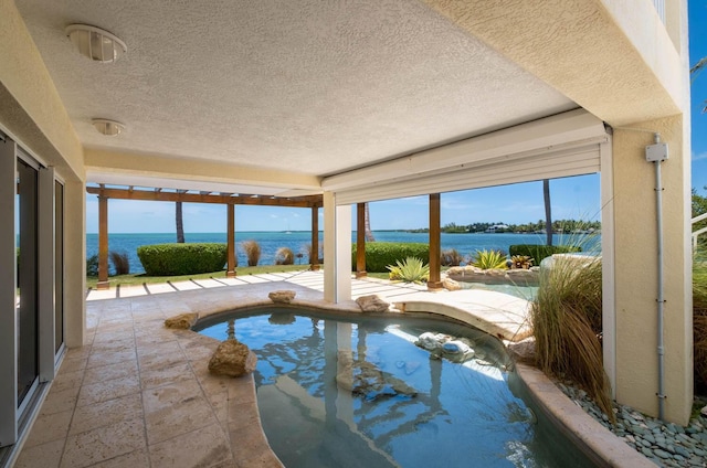 view of swimming pool featuring a jacuzzi and a water view