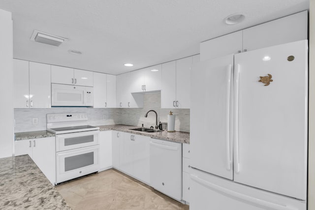 kitchen featuring white appliances, sink, backsplash, and white cabinets