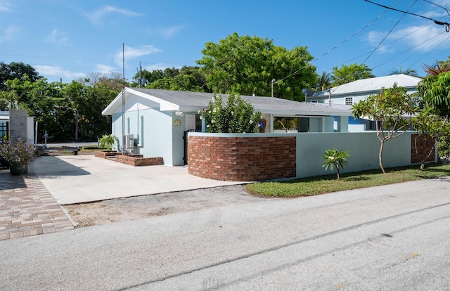 view of front of house featuring driveway, a fenced front yard, and stucco siding