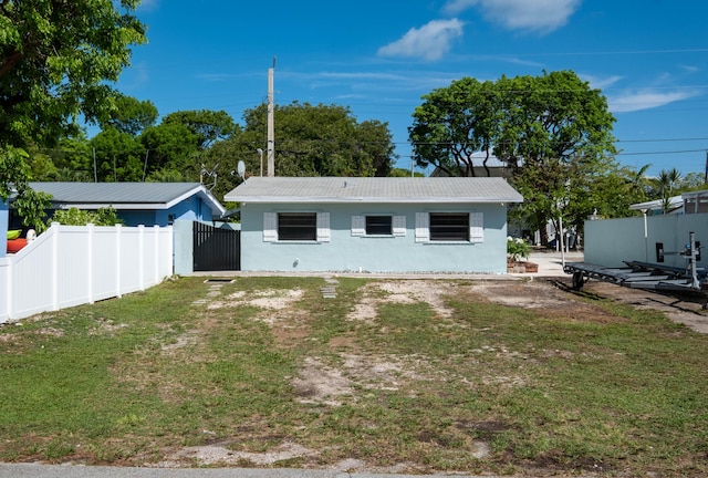 back of property featuring stucco siding, a lawn, and fence