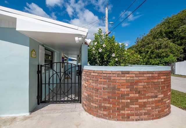 exterior space featuring a gate, fence, and stucco siding