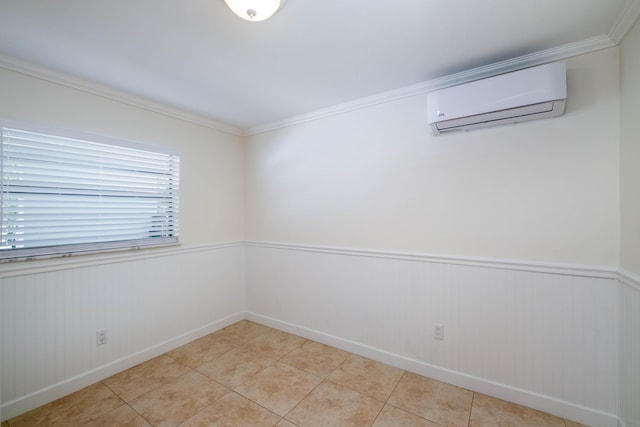 spare room with an AC wall unit, light tile patterned floors, crown molding, and wainscoting