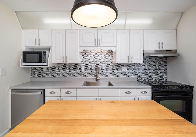 kitchen with under cabinet range hood, appliances with stainless steel finishes, light countertops, and a sink