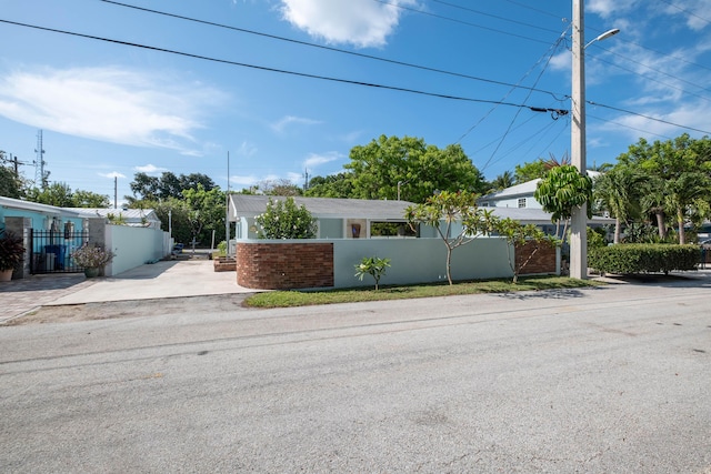 view of front facade featuring driveway, a fenced front yard, and stucco siding