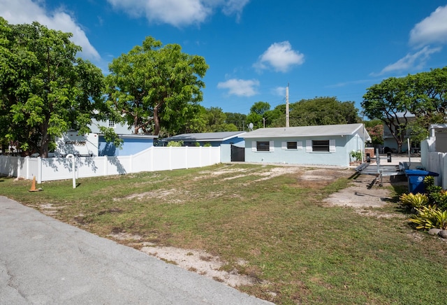 view of front of property with stucco siding, a front lawn, and fence