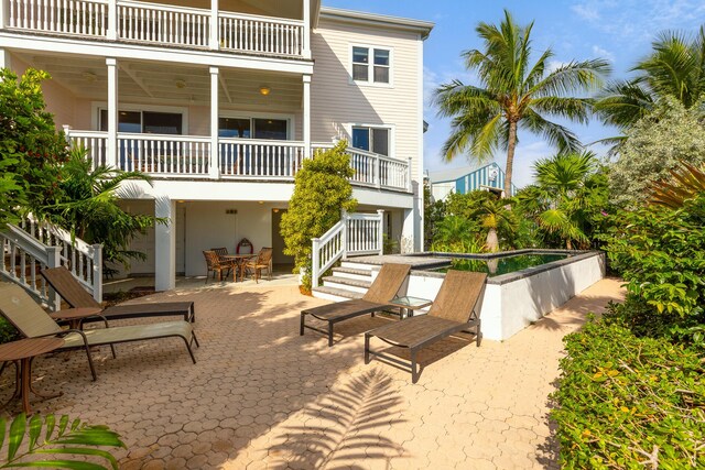 rear view of house with a patio area and a balcony