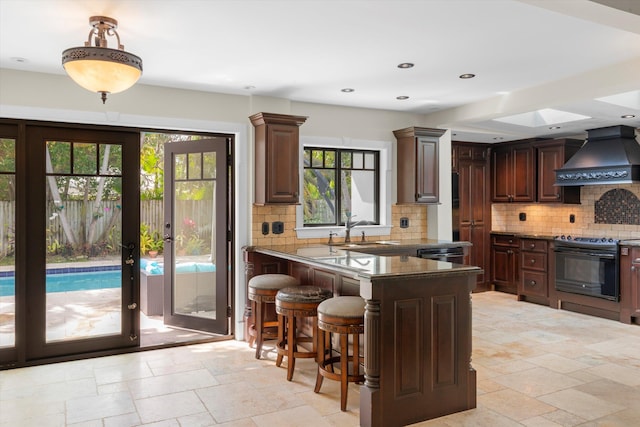3532 Duck Ave, Key West, FL 33040 - kitchen featuring a sink, black range with electric cooktop, stone tile floors, tasteful backsplash, and custom range hood