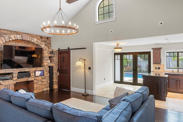 3532 Duck Ave, Key West, FL 33040 - living room featuring french doors, a barn door, baseboards, an inviting chandelier, and high vaulted ceiling
