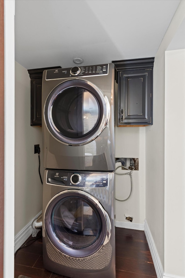 3532 Duck Ave, Key West, FL 33040 - clothes washing area with baseboards, stacked washer and dryer, cabinet space, and wood finished floors