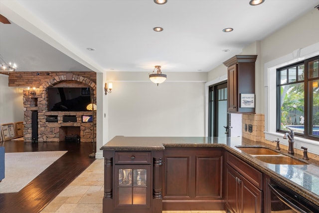 3532 Duck Ave, Key West, FL 33040 - kitchen featuring dishwasher, a sink, a peninsula, dark stone countertops, and a fireplace