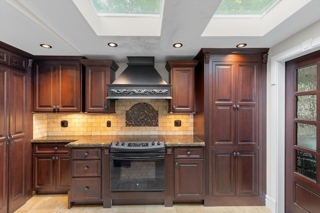 3532 Duck Ave, Key West, FL 33040 - kitchen with a skylight, dark stone counters, recessed lighting, black range with electric stovetop, and custom range hood