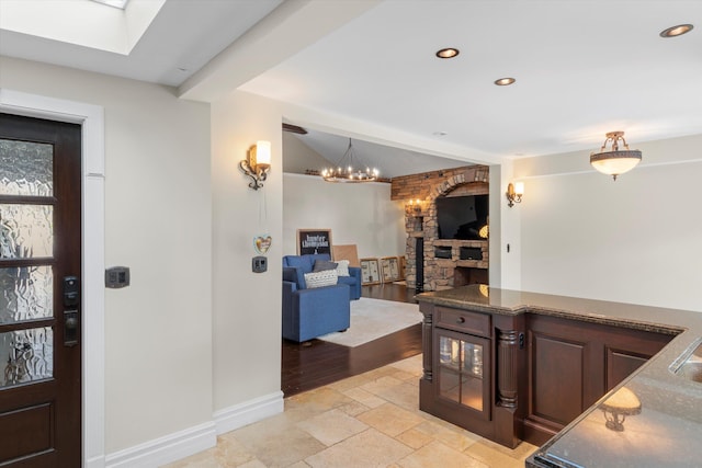 3532 Duck Ave, Key West, FL 33040 - foyer entrance featuring a skylight, recessed lighting, stone tile floors, an inviting chandelier, and baseboards