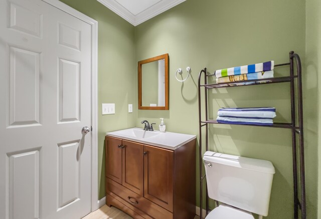 bathroom featuring vanity, crown molding, and toilet