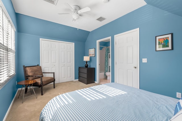 carpeted bedroom with ceiling fan, a closet, vaulted ceiling, and multiple windows